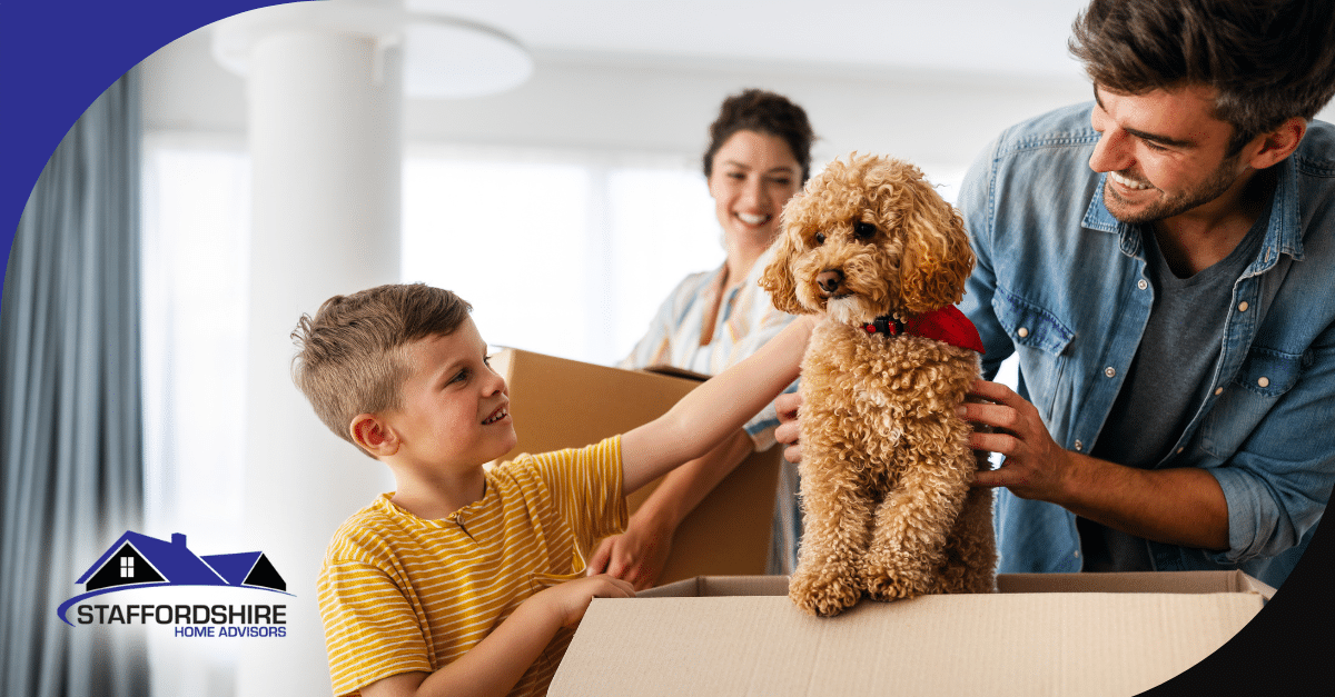 Family smiling as they unpack their dog from a moving box.